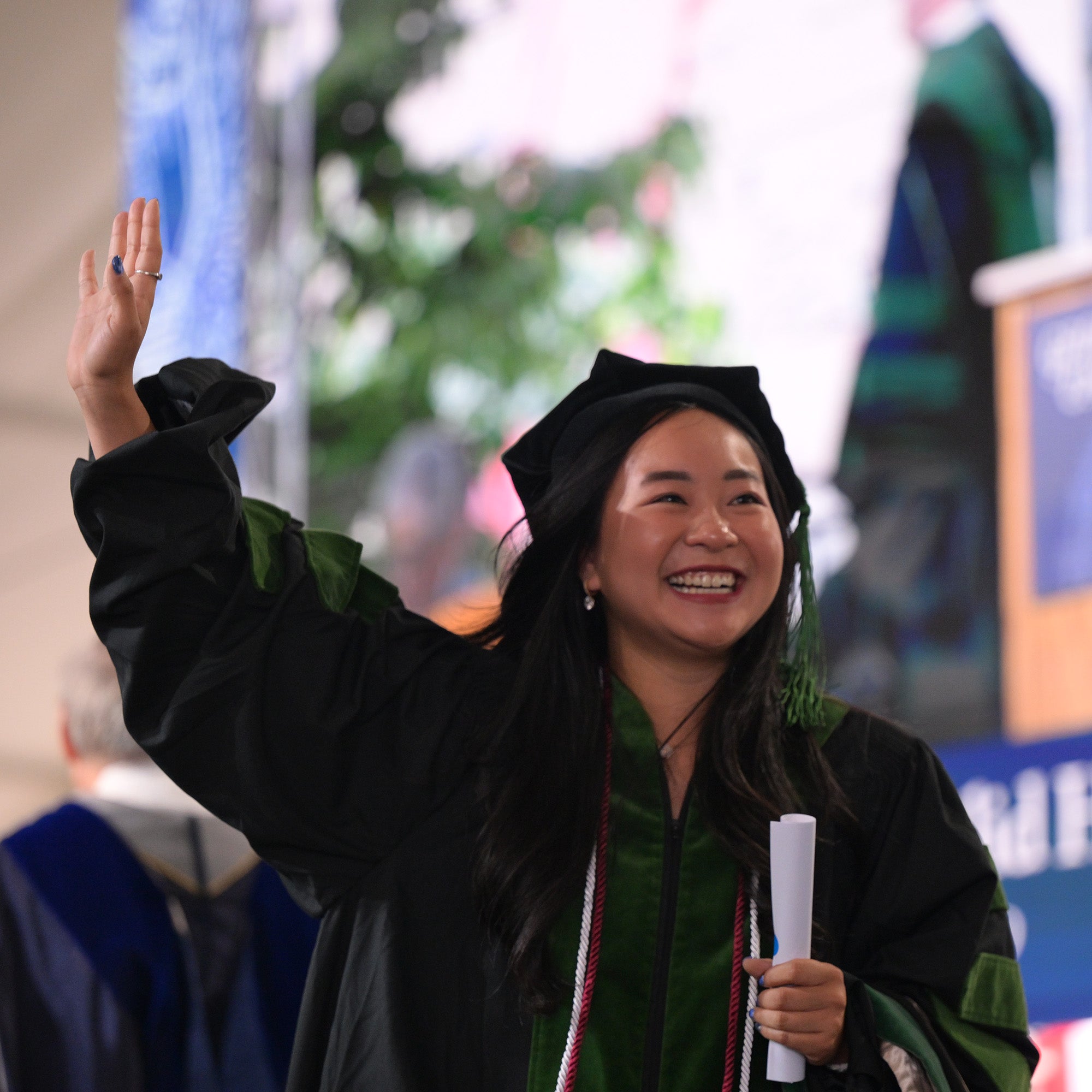 A graduating medical student raises her hand in celebration
