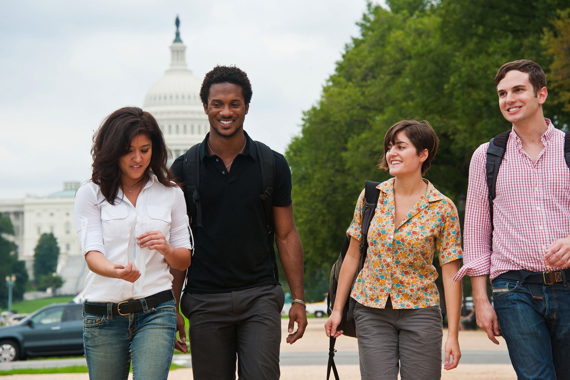 Four students walk on the National Mall with the Capitol Building in the background