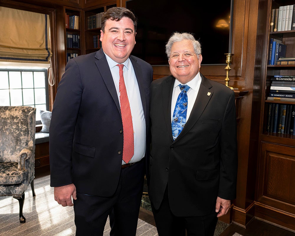Ryan Murray and William Oppenheim stand together in a wood-paneled room