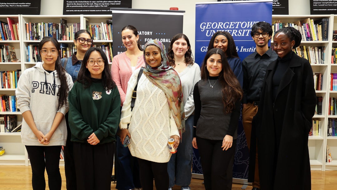 A group of students stands together in the library