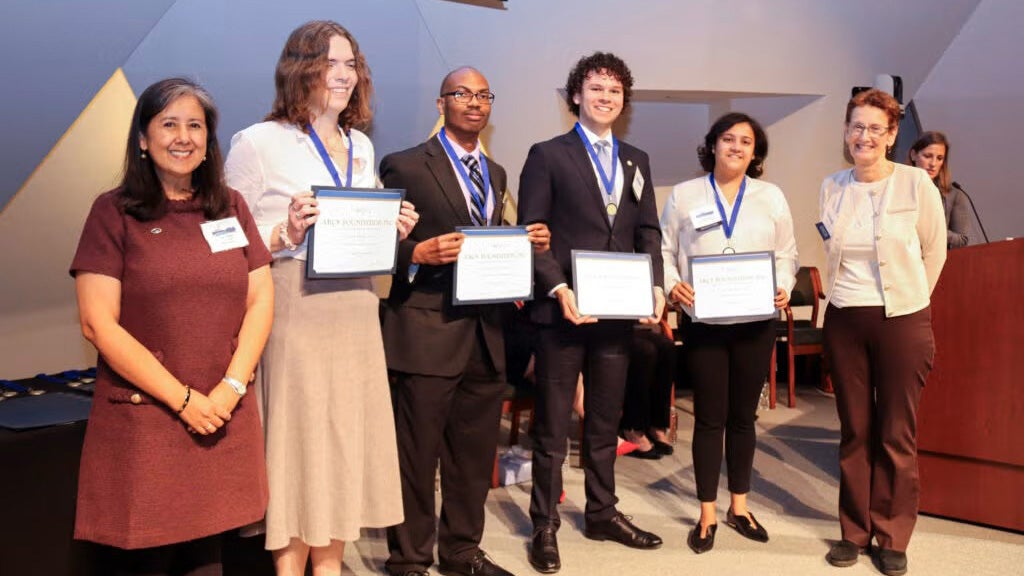 Six individuals including the four ARCS Scholars stand together