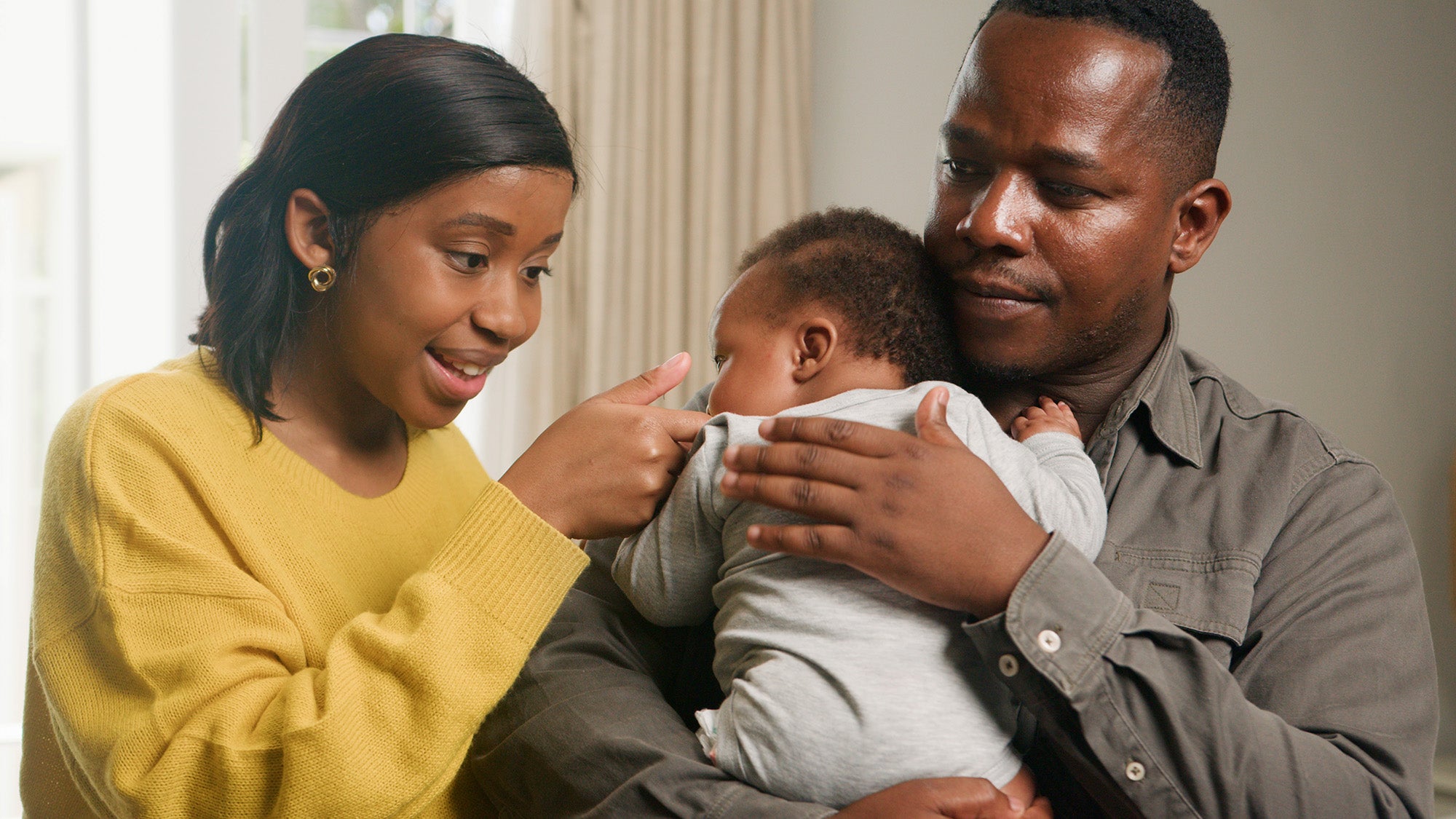 A Black couple interacts with their baby
