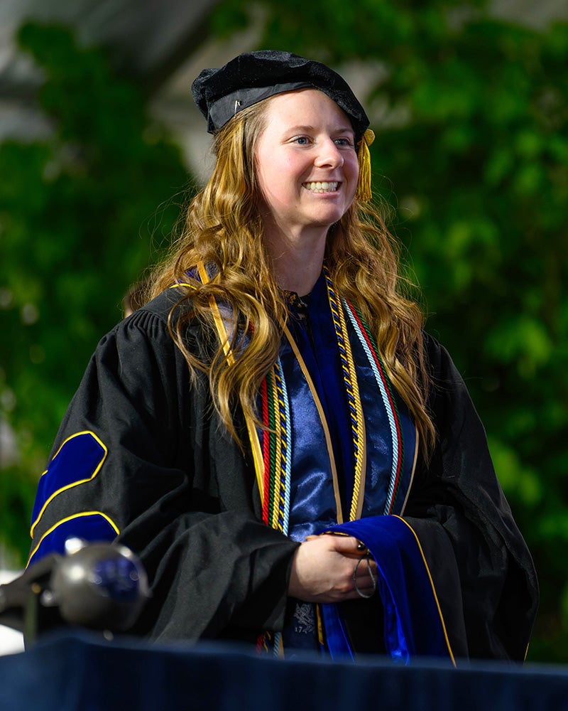 Micaila Curtis stands in cap and gown