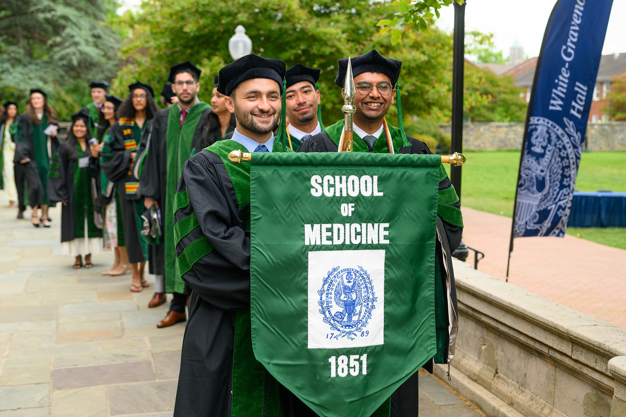 Two MD grads carry the School of Medicine banner