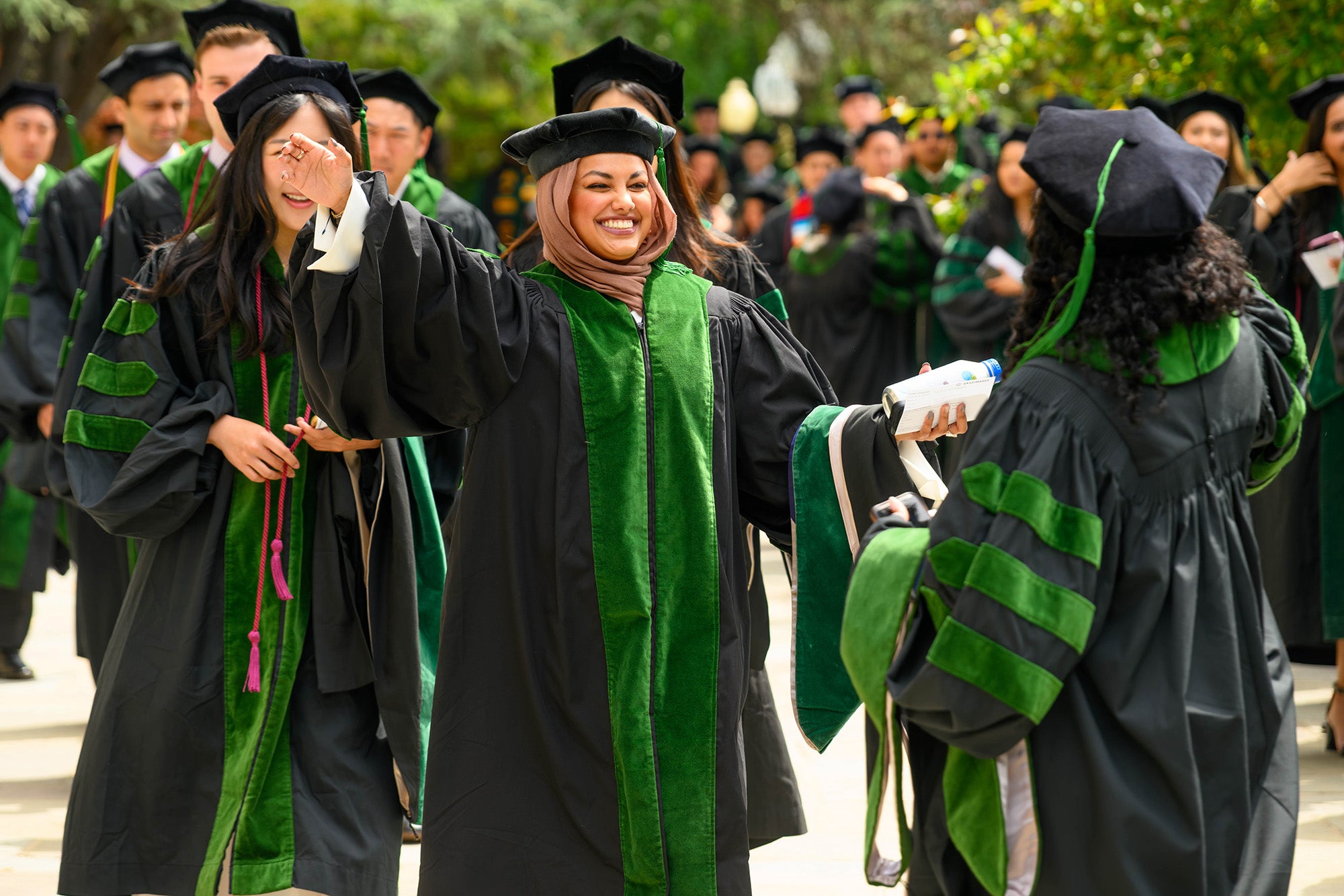Students embrace on the walk to commencement