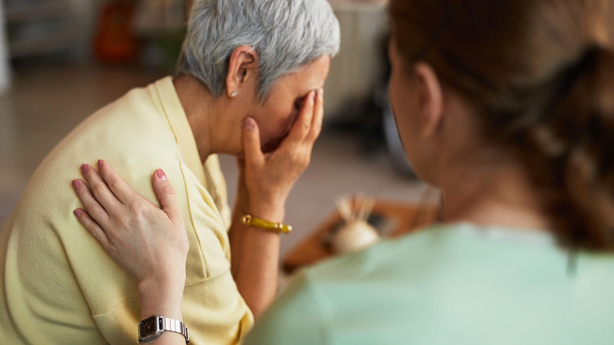 A nurse comforts a woman who is agitated